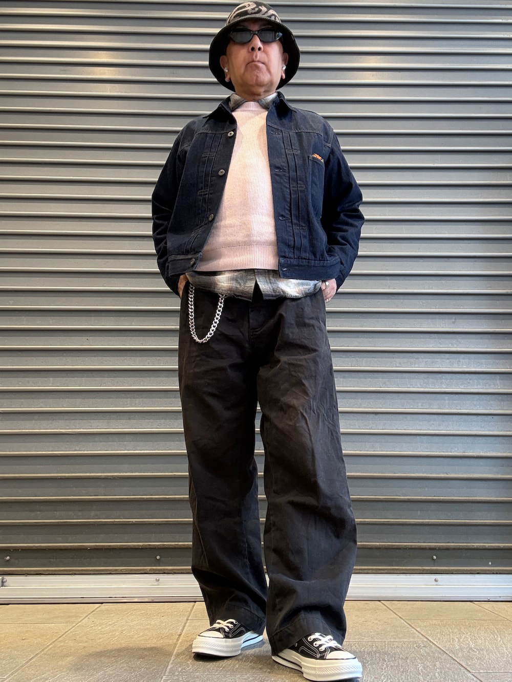 ピンク系のニット/セーター、ブラック系のシャツ/ブラウス、ブルー系のデニムジャケットを着用したメンズの春コーディネートの2枚目の写真