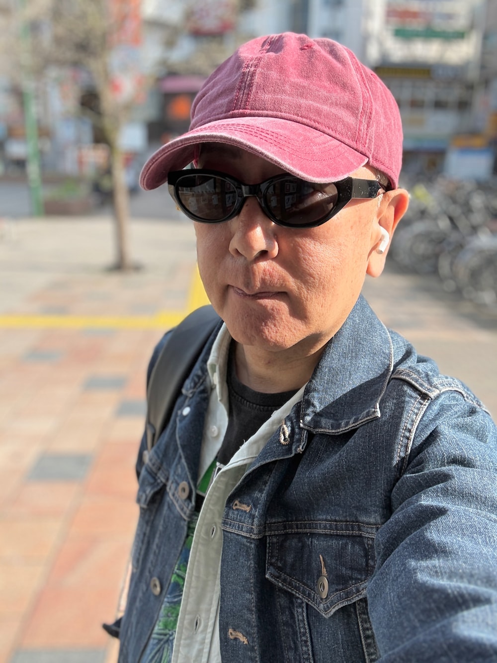 レッド系のスニーカー、グリーン系のシャツ/ブラウス、ブラック系のTシャツ/カットソーを着用したメンズの春コーディネートの3枚目の写真