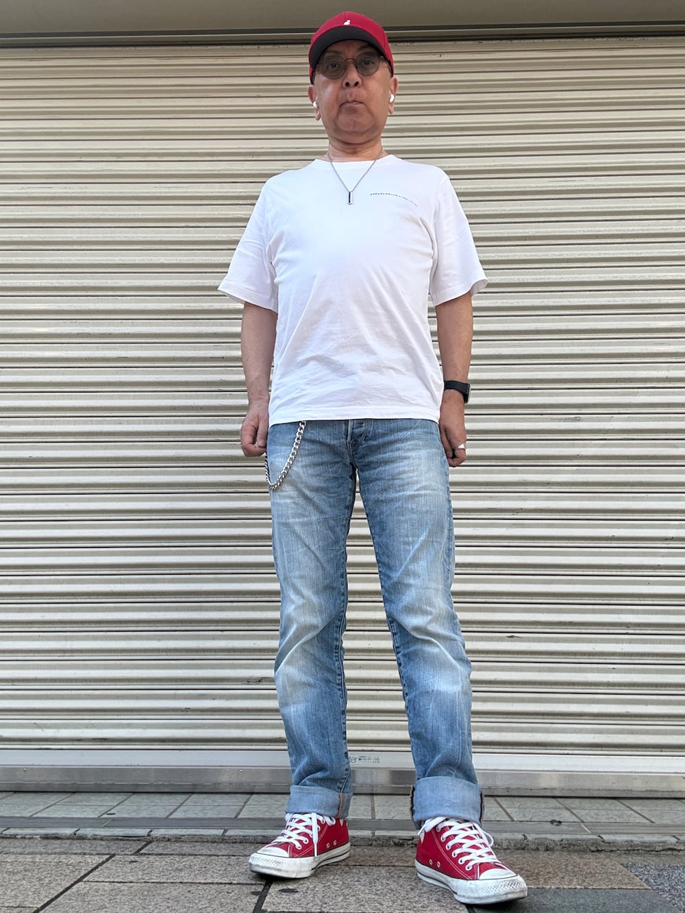 ホワイト系のTシャツ/カットソー、ブルー系のデニムパンツ、レッド系のスニーカーを着用したメンズの春コーディネートの2枚目の写真