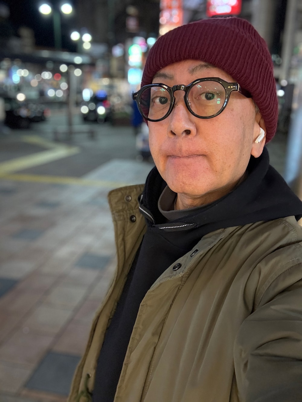 ブラック系のパーカー、グリーン系のモッズコート、グレー系のデニムパンツを着用したメンズの冬コーディネートの3枚目の写真