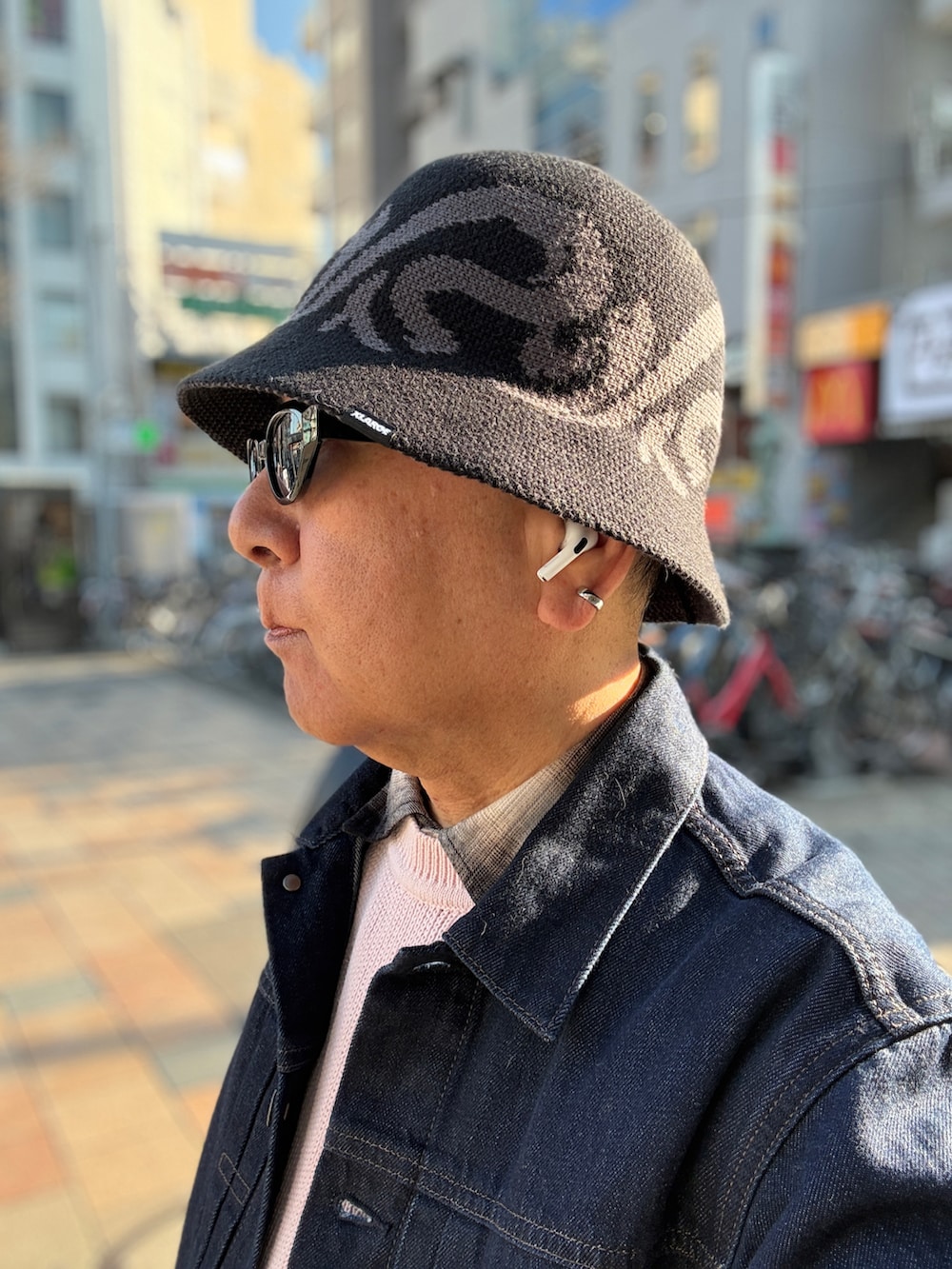 ピンク系のニット/セーター、ブラック系のシャツ/ブラウス、ブルー系のデニムジャケットを着用したメンズの春コーディネートの4枚目の写真