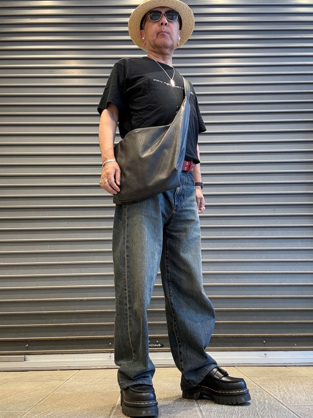 ブルー系のデニムパンツ、ブラック系のTシャツ/カットソー、ブラック系のボディバッグ/ウエストポーチを着用したメンズの夏コーディネートの2枚目の写真