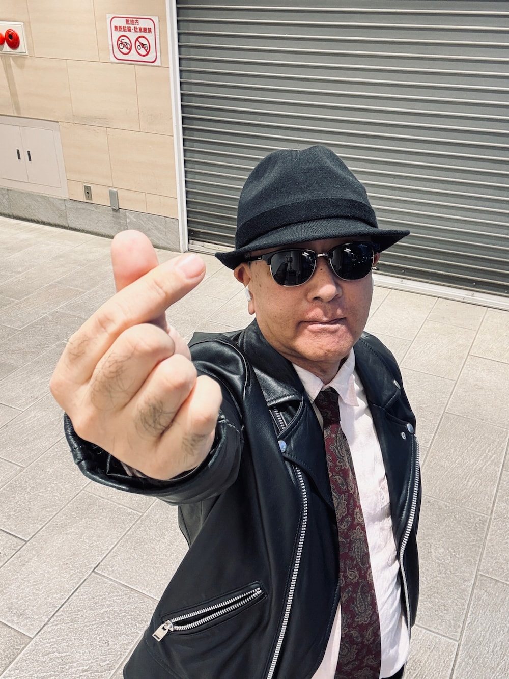 ブラック系のライダースジャケット、ブルー系のデニムパンツ、ピンク系のシャツ/ブラウスを着用したメンズの冬コーディネートの2枚目の写真