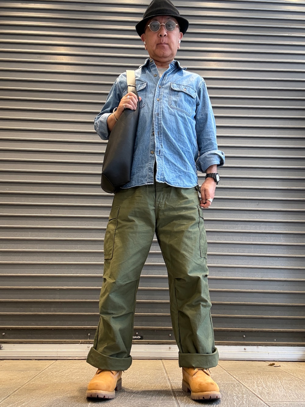 グリーン系のカーゴパンツ、ブルー系のシャツ/ブラウス、ブラック系のトートバッグを着用したメンズの夏コーディネートの2枚目の写真