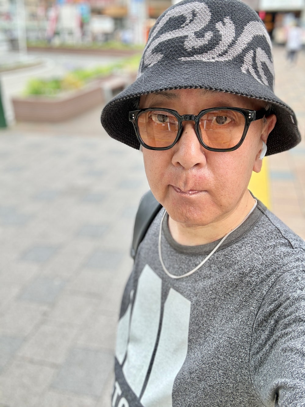 ホワイト系のスニーカー、グレー系のTシャツ/カットソー、レッド系のデニムパンツを着用したメンズの春コーディネートの4枚目の写真