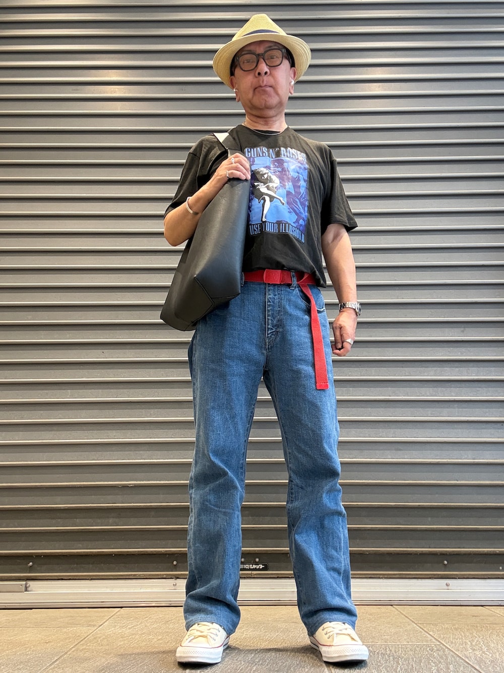ブルー系のデニムパンツ、ブラック系のTシャツ/カットソー、ブラック系のトートバッグを着用したメンズの夏コーディネートの2枚目の写真