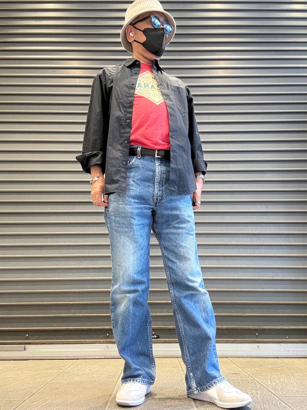 ブラック系のシャツ/ブラウス、レッド系のTシャツ/カットソー、ブルー系のデニムパンツを着用したメンズの春コーディネートの2枚目の写真