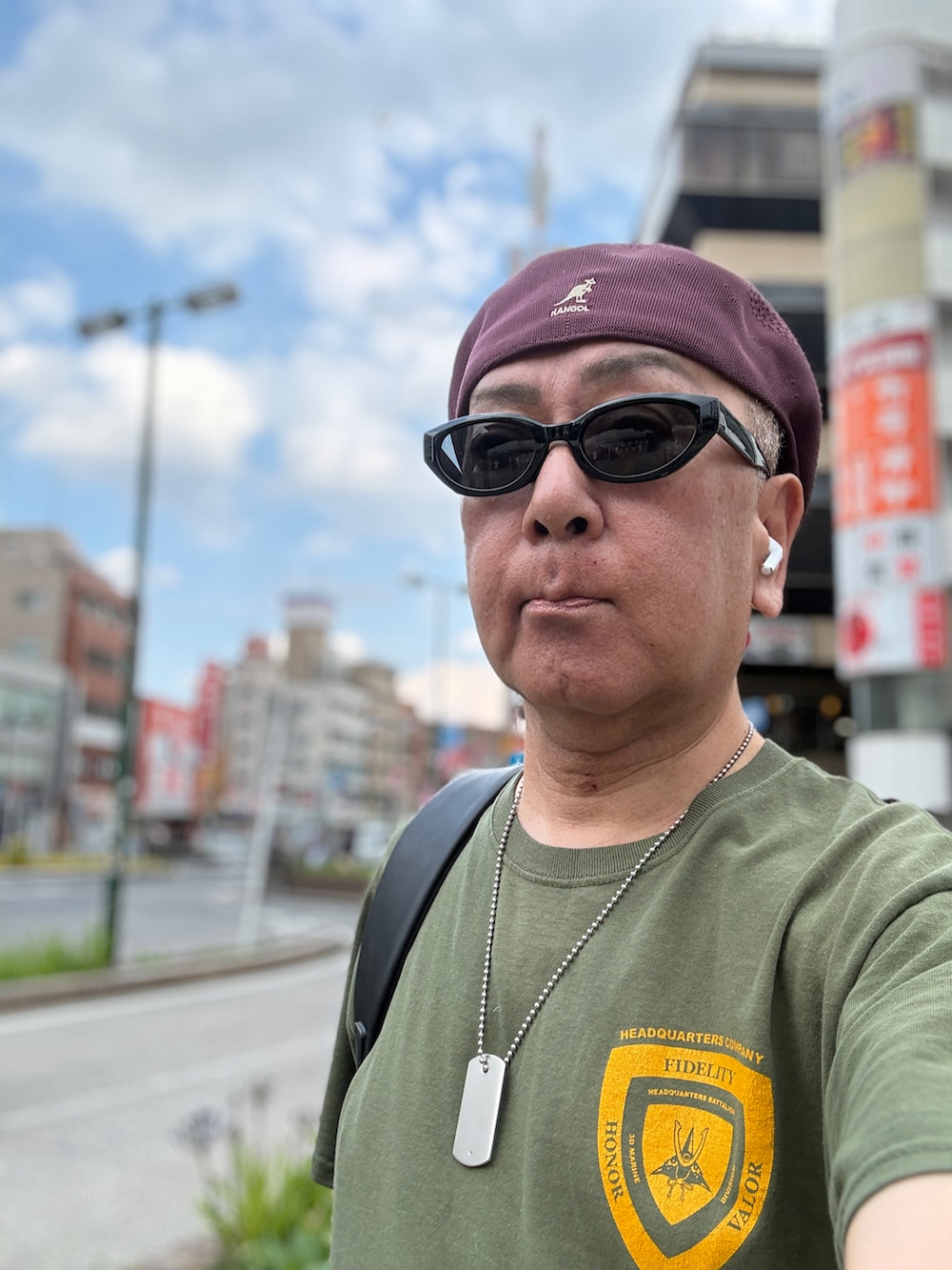 ブルー系のデニムパンツ、グリーン系のTシャツ/カットソー、レッド系のスニーカーを着用したメンズの春コーディネートの4枚目の写真