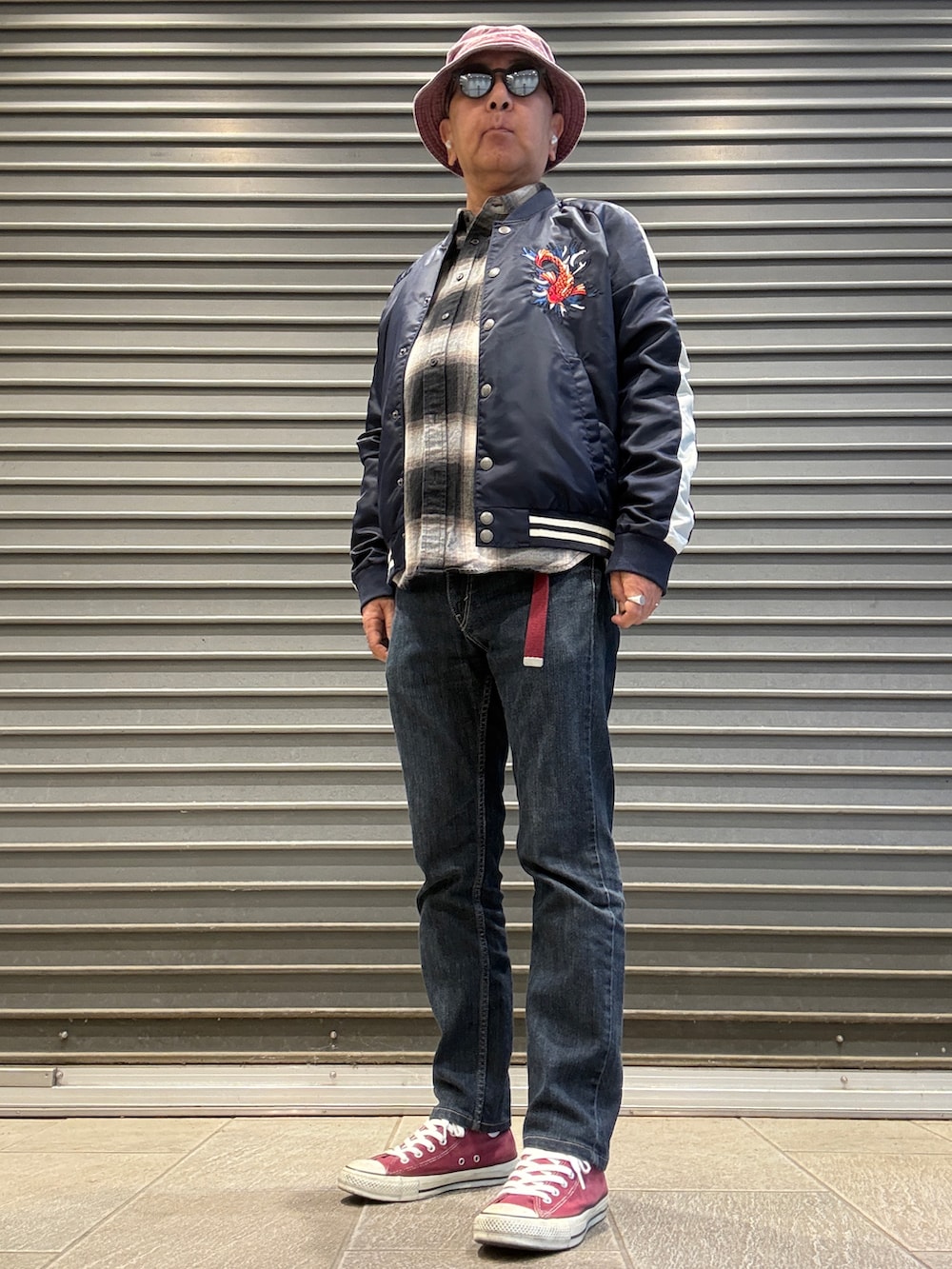 ブラック系のデニムパンツ、ブラック系のシャツ/ブラウス、ブルー系のスカジャンを着用したメンズの春コーディネートの3枚目の写真
