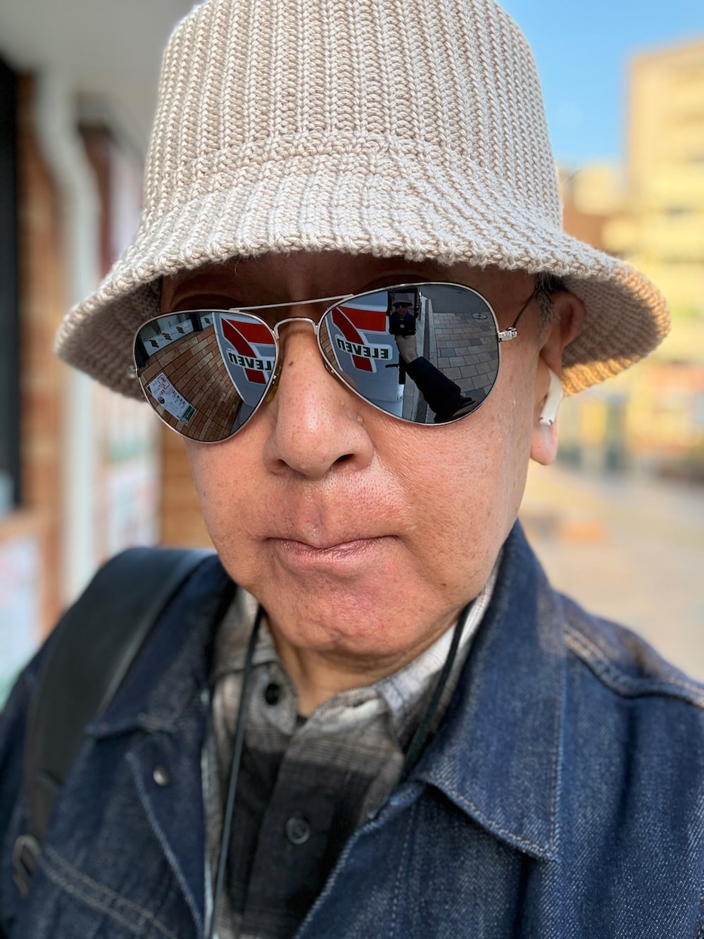 ブルー系のデニムジャケット、ホワイト系のベスト、ブラック系のシャツ/ブラウスを着用したメンズの春コーディネートの2枚目の写真