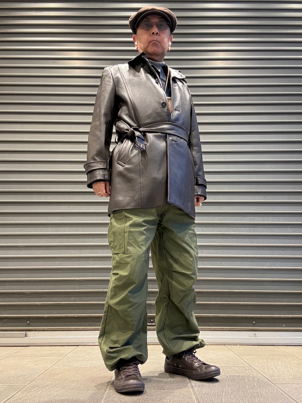 グレー系のTシャツ/カットソー、ブルー系のデニムジャケット、ブラウン系のトレンチコートを着用したメンズの冬コーディネートの2枚目の写真