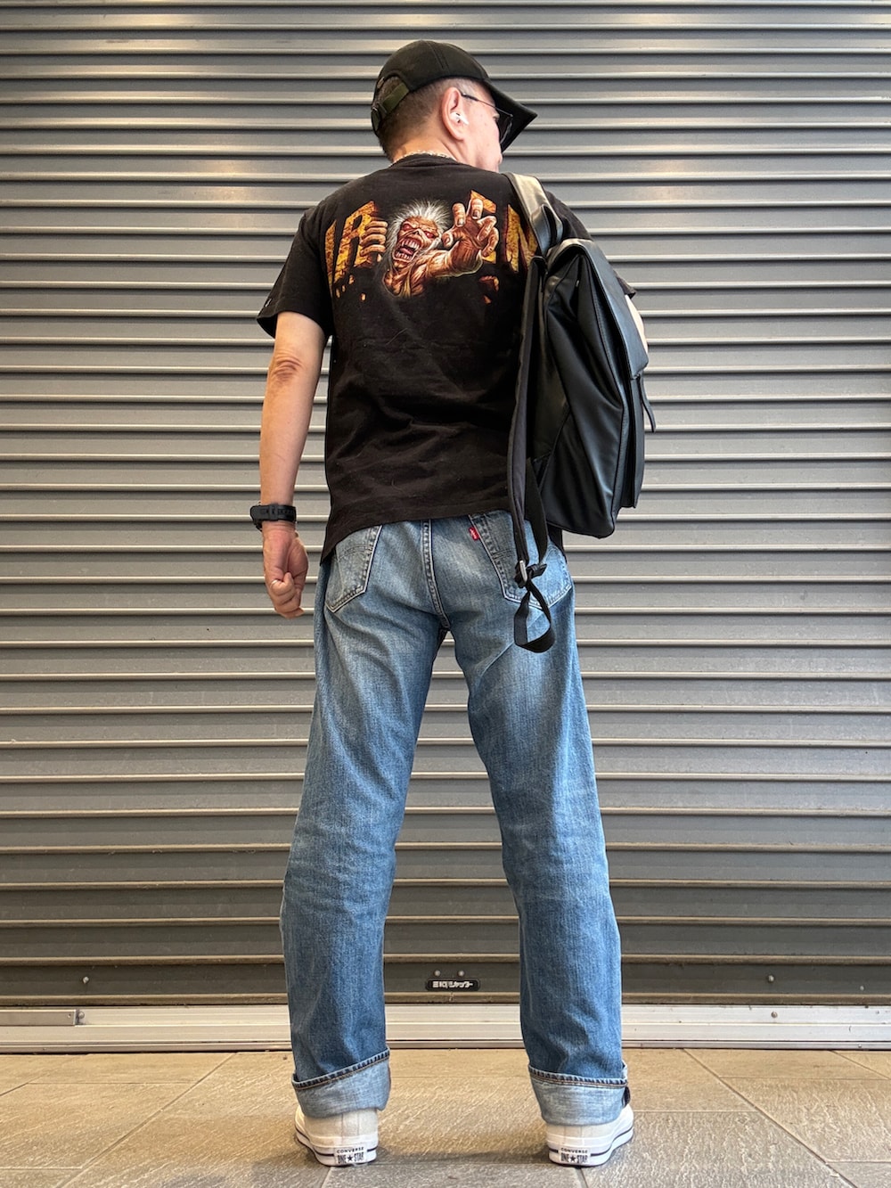 ブラック系のTシャツ/カットソー、ブルー系のデニムパンツ、ブラック系のバックパック/リュックを着用したメンズの秋コーディネートの2枚目の写真