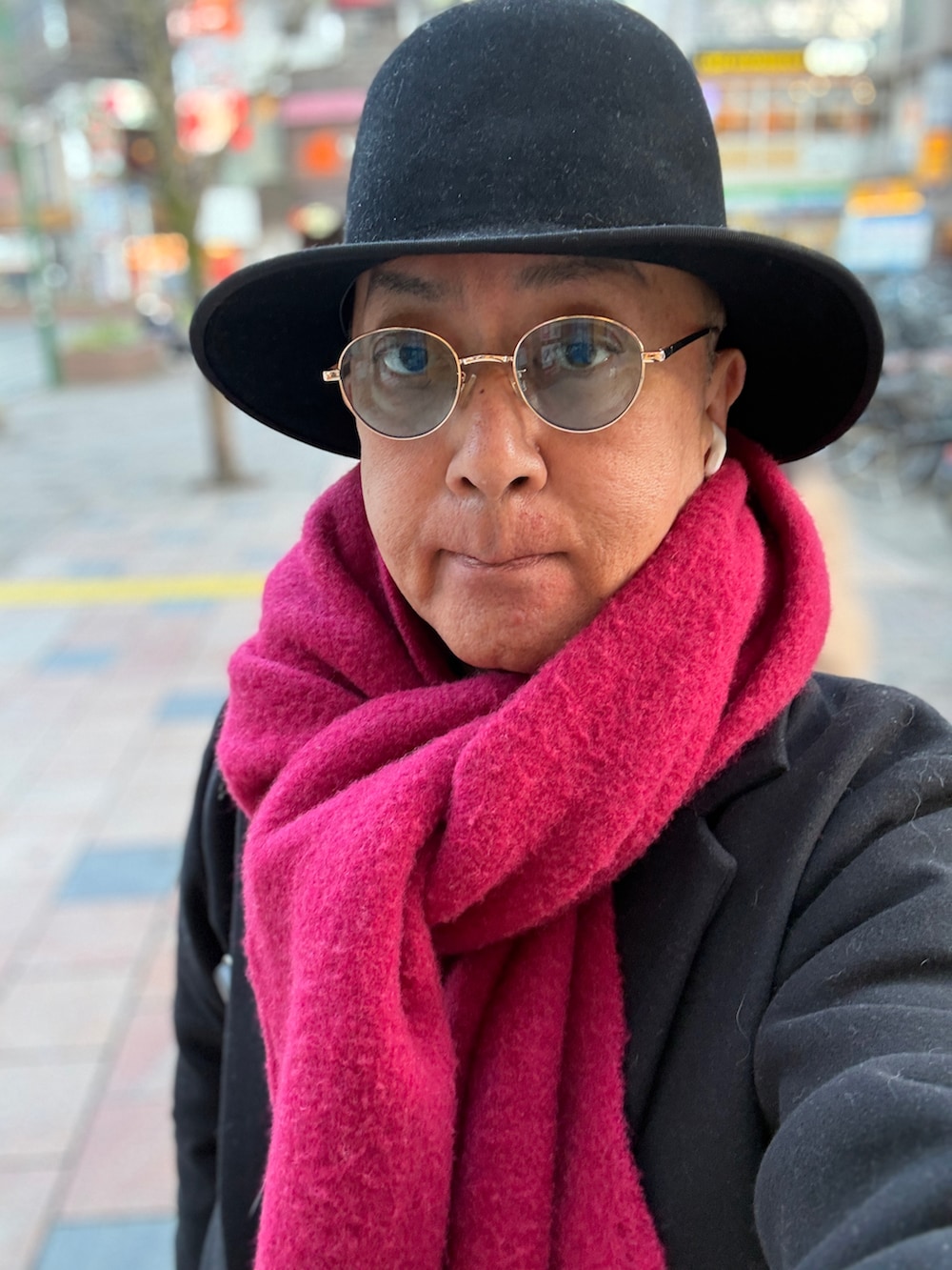 グレー系のニット/セーター、ブラック系のチェスターコート、ブルー系のデニムパンツを着用したメンズの春コーディネートの4枚目の写真