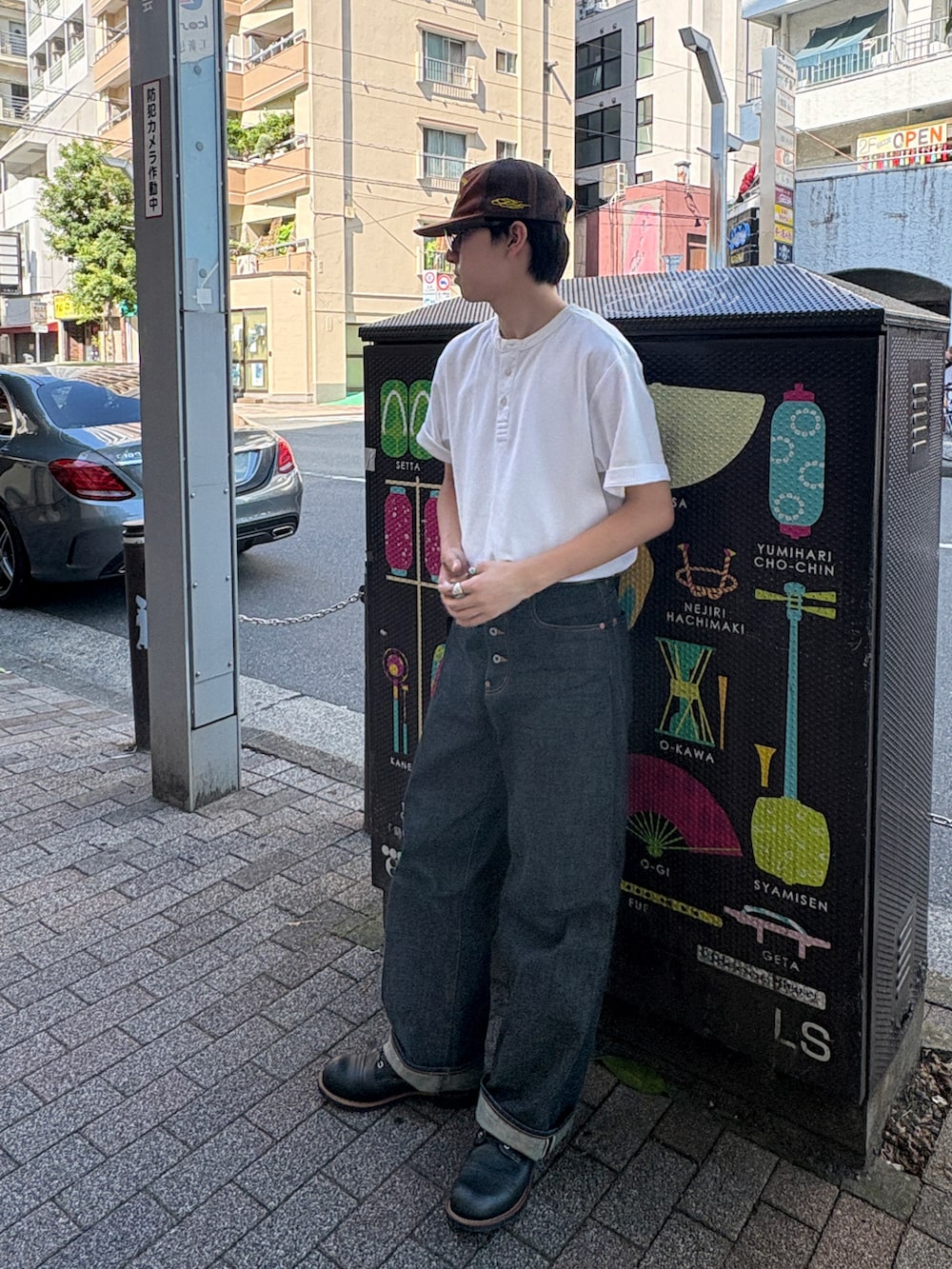 ブルー系のデニムパンツ、ブラック系のブーツ、ホワイト系のその他トップスを着用したメンズの夏コーディネートの3枚目の写真