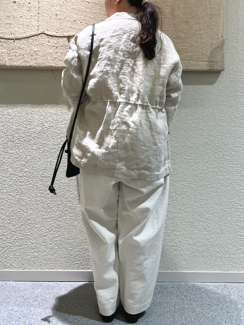 ベージュ系のその他パンツ、ブラック系のバレエシューズ、ブラック系のショルダーバッグを着用したレディースの冬コーディネートの4枚目の写真