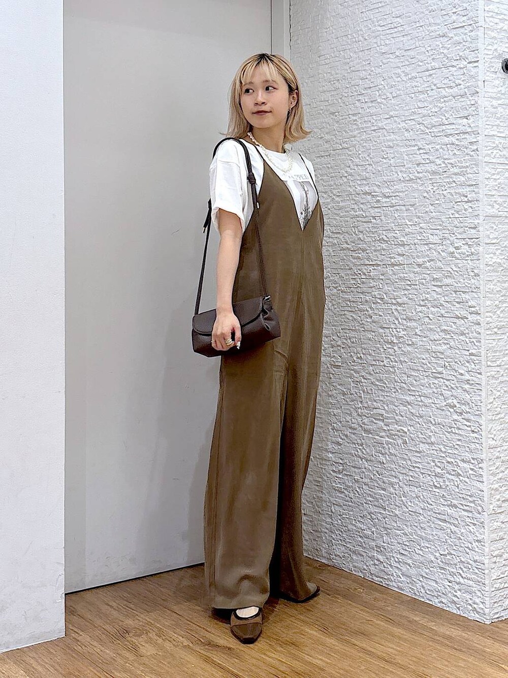 ブラウン系のショルダーバッグ、ホワイト系のTシャツ/カットソー、ブラウン系のパンプスを着用したレディースの夏コーディネートの5枚目の写真