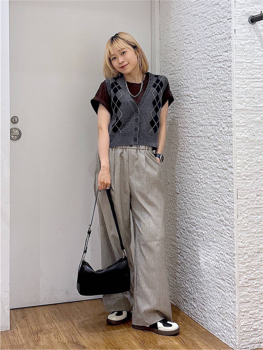 グレー系のベスト、ブラック系のスニーカー、ブラウン系のTシャツ/カットソーを着用したレディースの夏コーディネートの5枚目の写真