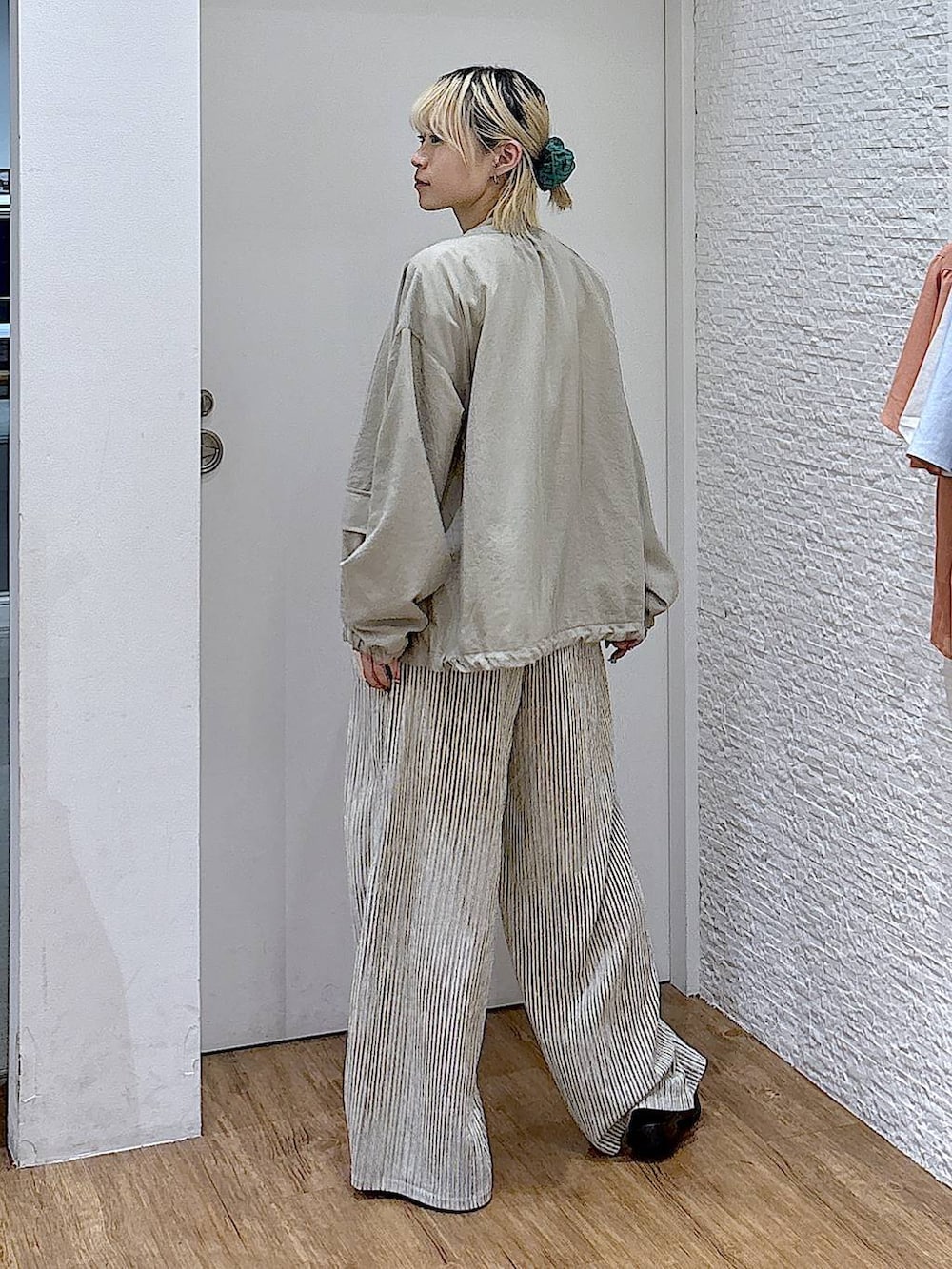 グリーン系のブルゾン、ホワイト系のTシャツ/カットソー、ブラック系のサンダルを着用したレディースの夏コーディネートの3枚目の写真
