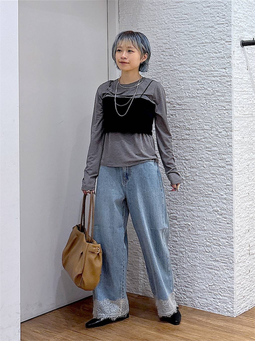 ブラック系のパンプス、グレー系のTシャツ/カットソー、ブルー系のデニムパンツを着用したレディースの秋コーディネートの2枚目の写真