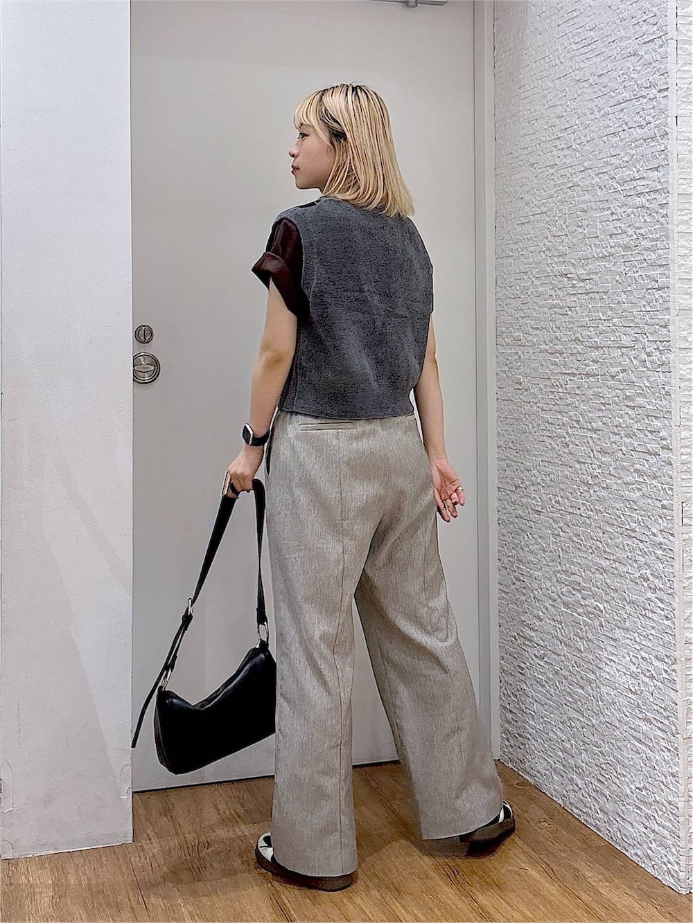 グレー系のベスト、ブラック系のスニーカー、ブラウン系のTシャツ/カットソーを着用したレディースの夏コーディネートの3枚目の写真