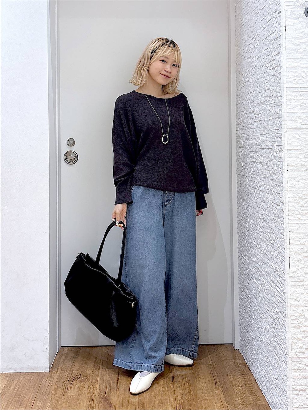 ベージュ系のパンプス、ブラック系のボストンバッグ、グレー系のニット/セーターを着用したレディースの夏コーディネートの5枚目の写真