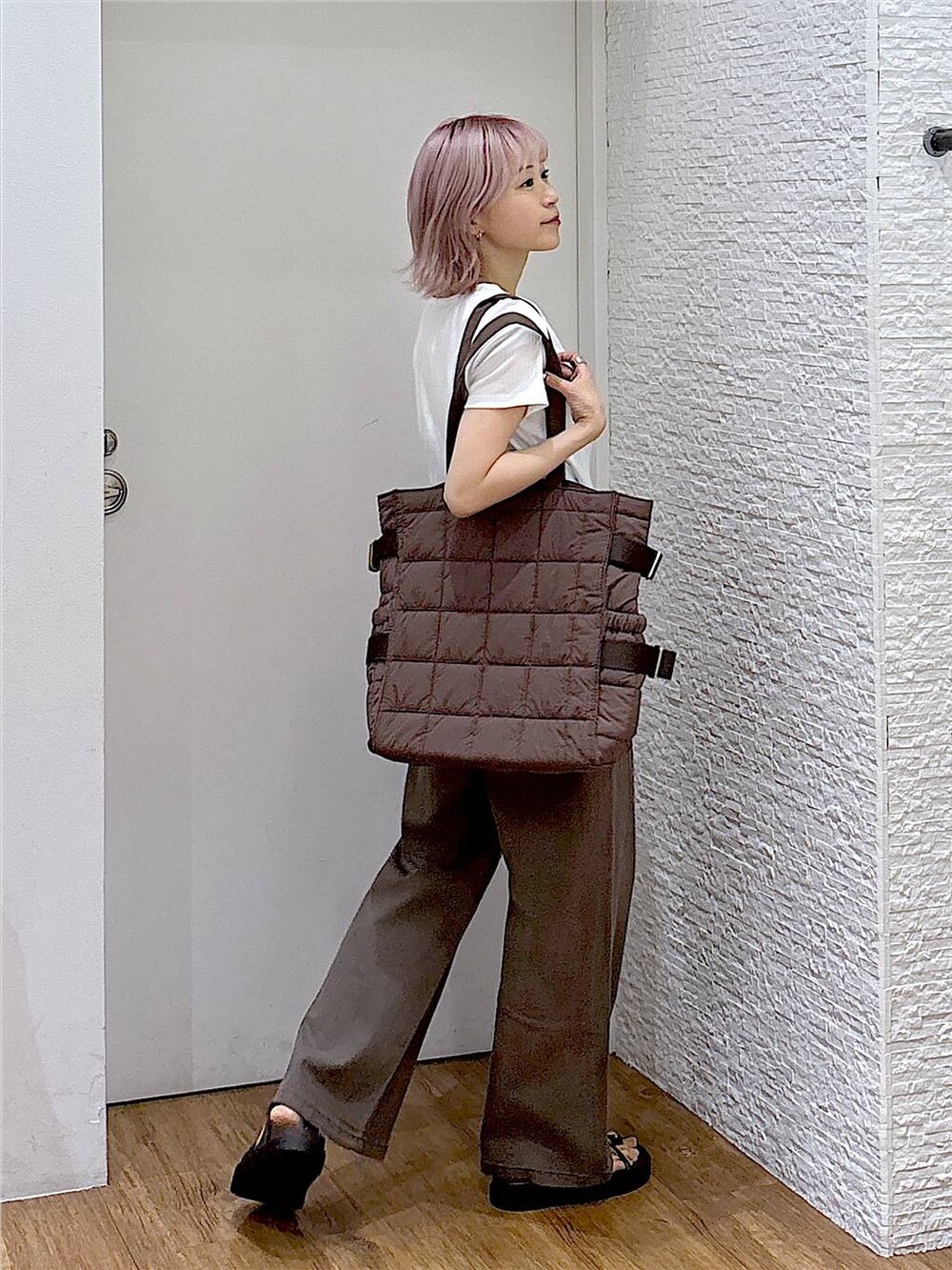 ブラウン系のデニムパンツ、ブラウン系のサンダル、ブラウン系のトートバッグを着用したレディースの夏コーディネートの4枚目の写真