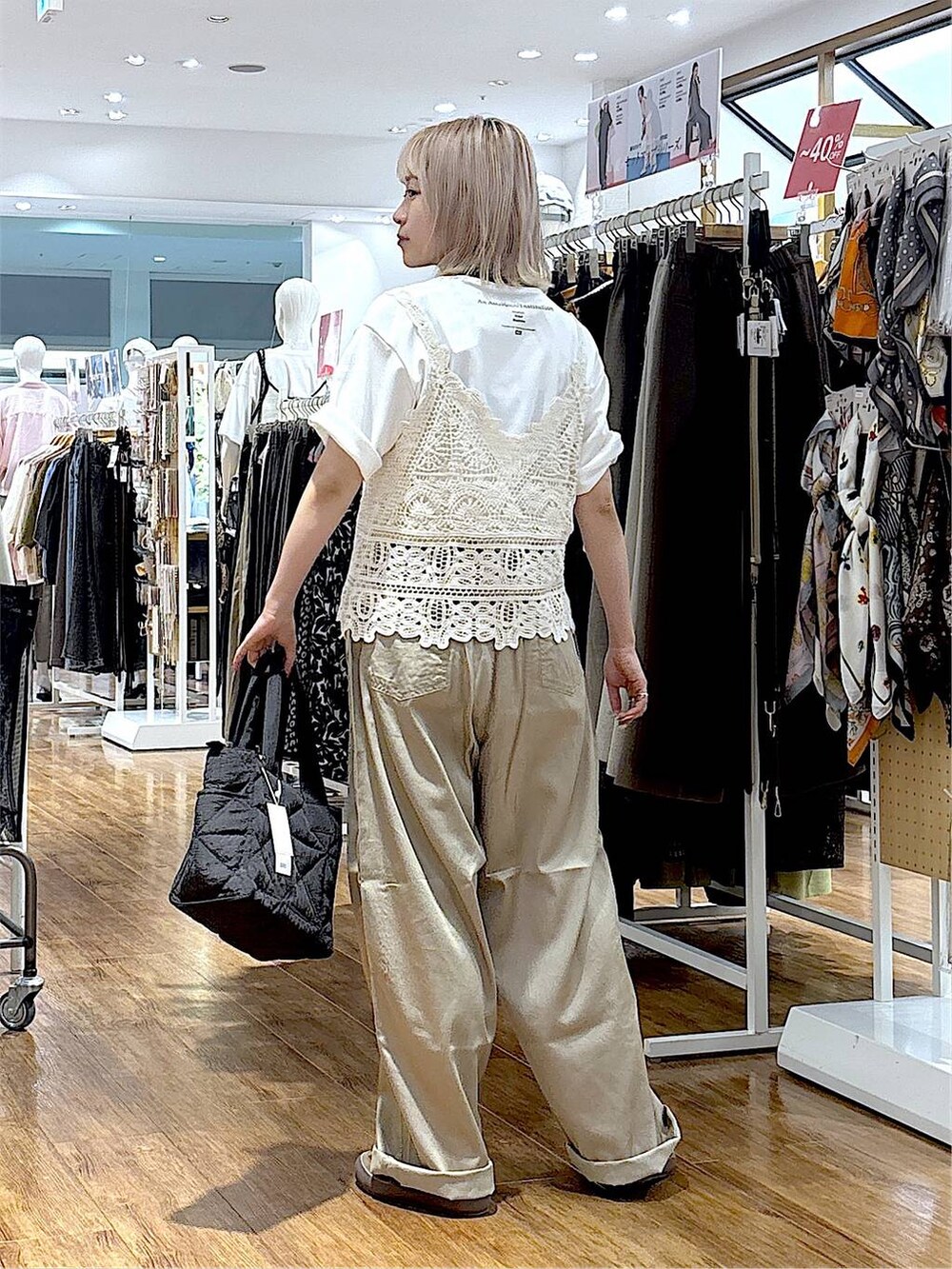 ブラウン系のスニーカー、ブラック系のトートバッグ、ベージュ系のその他パンツを着用したレディースの夏コーディネートの3枚目の写真