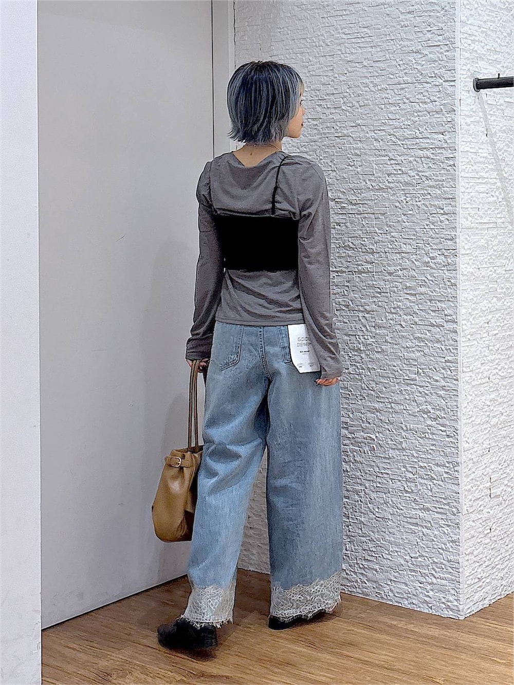 ブラック系のパンプス、グレー系のTシャツ/カットソー、ブルー系のデニムパンツを着用したレディースの秋コーディネートの4枚目の写真