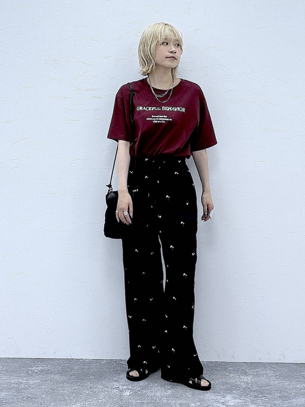 レッド系のTシャツ/カットソー、ブラック系のその他パンツ、ブラック系のサンダルを着用したレディースの夏コーディネートの5枚目の写真