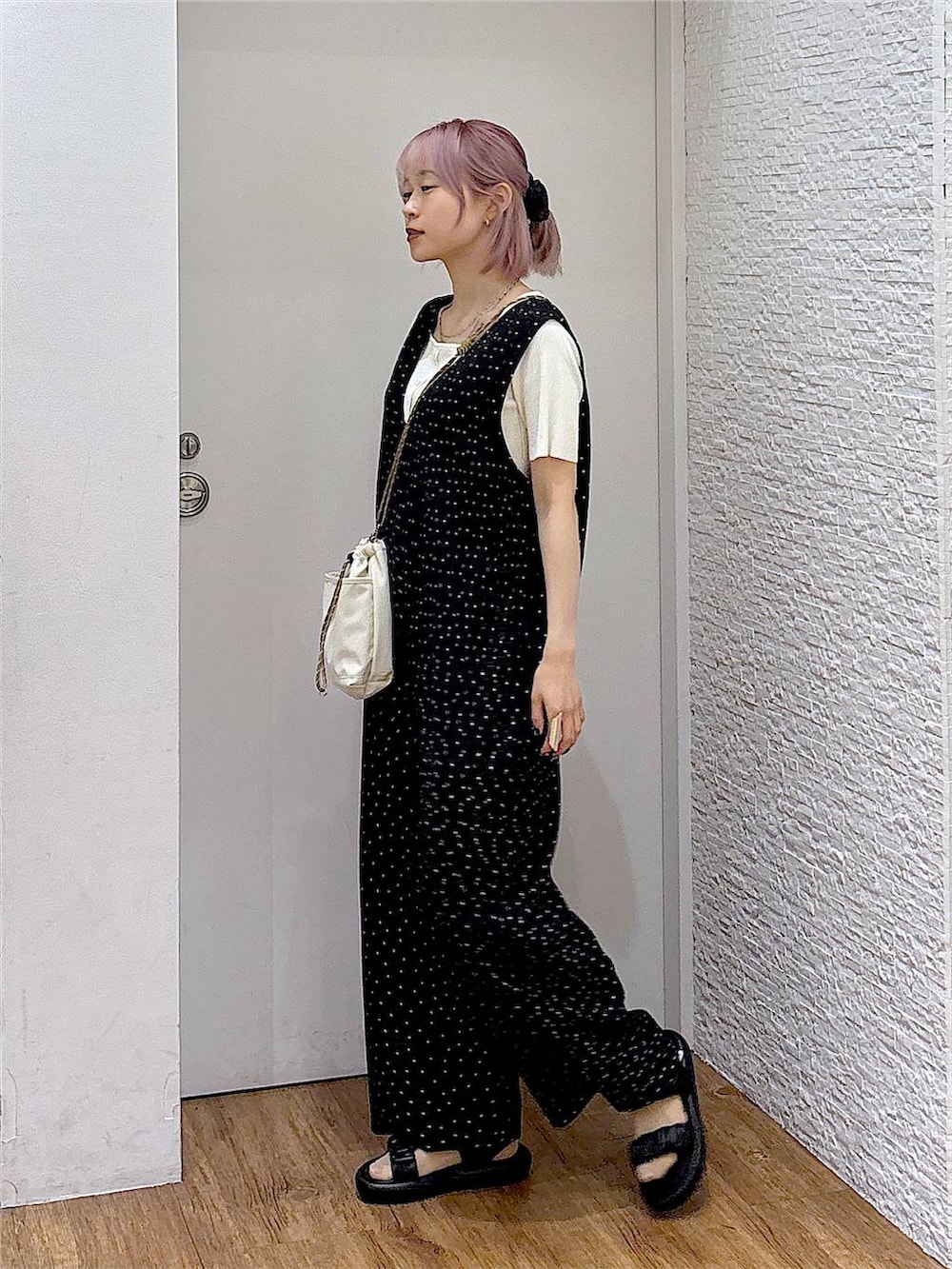 ブラック系のサロペット/オーバーオール、ベージュ系のボディバッグ/ウエストポーチ、ホワイト系のニット/セーターを着用したレディースの夏コーディネートの2枚目の写真