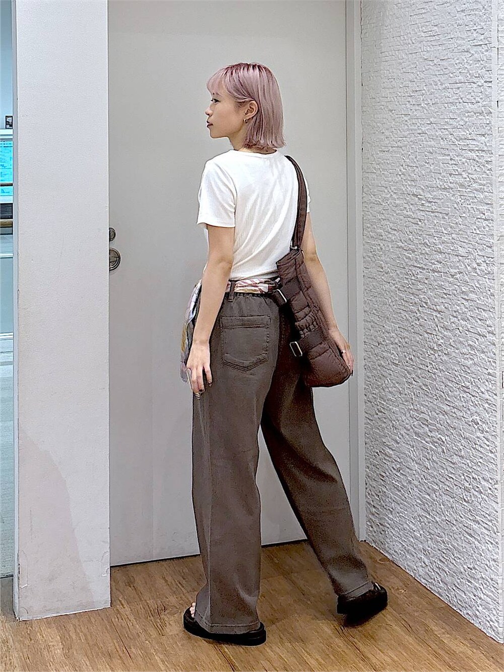 ブラウン系のデニムパンツ、ブラウン系のサンダル、ブラウン系のトートバッグを着用したレディースの夏コーディネートの3枚目の写真