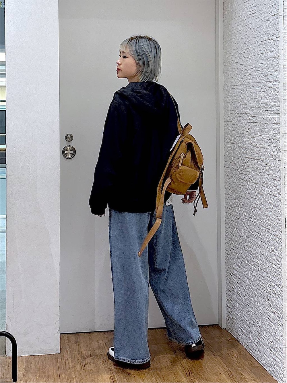 ブラウン系のバックパック/リュック、ホワイト系のTシャツ/カットソー、ブラック系のスニーカーを着用したレディースの秋コーディネートの3枚目の写真
