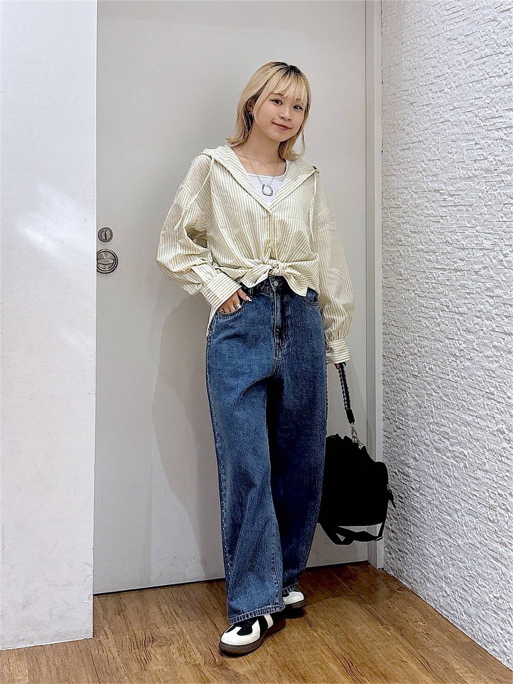 ブルー系のデニムパンツ、ブラック系のスニーカー、グレー系のタンクトップを着用したレディースの夏コーディネートの5枚目の写真