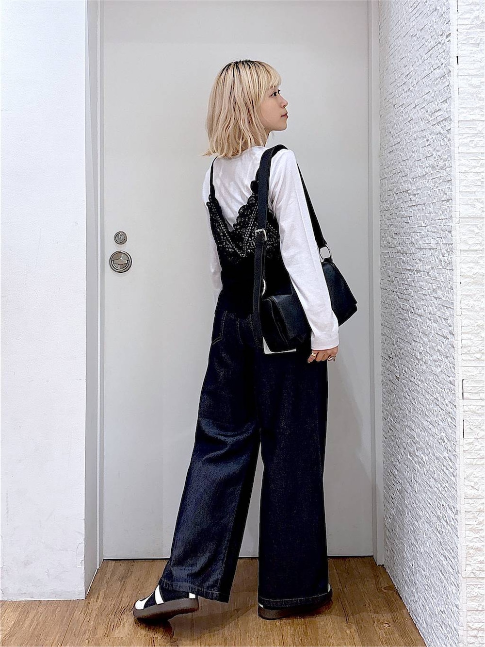 グレー系のTシャツ/カットソー、ブラック系のスニーカー、ブラック系のショルダーバッグを着用したレディースの秋コーディネートの4枚目の写真