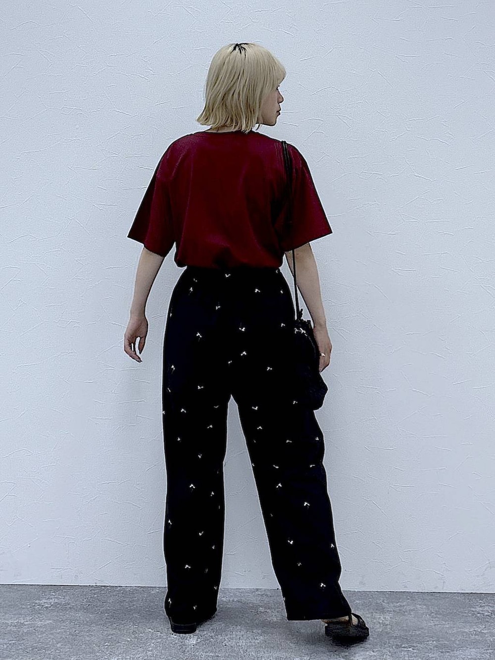 レッド系のTシャツ/カットソー、ブラック系のその他パンツ、ブラック系のサンダルを着用したレディースの夏コーディネートの3枚目の写真