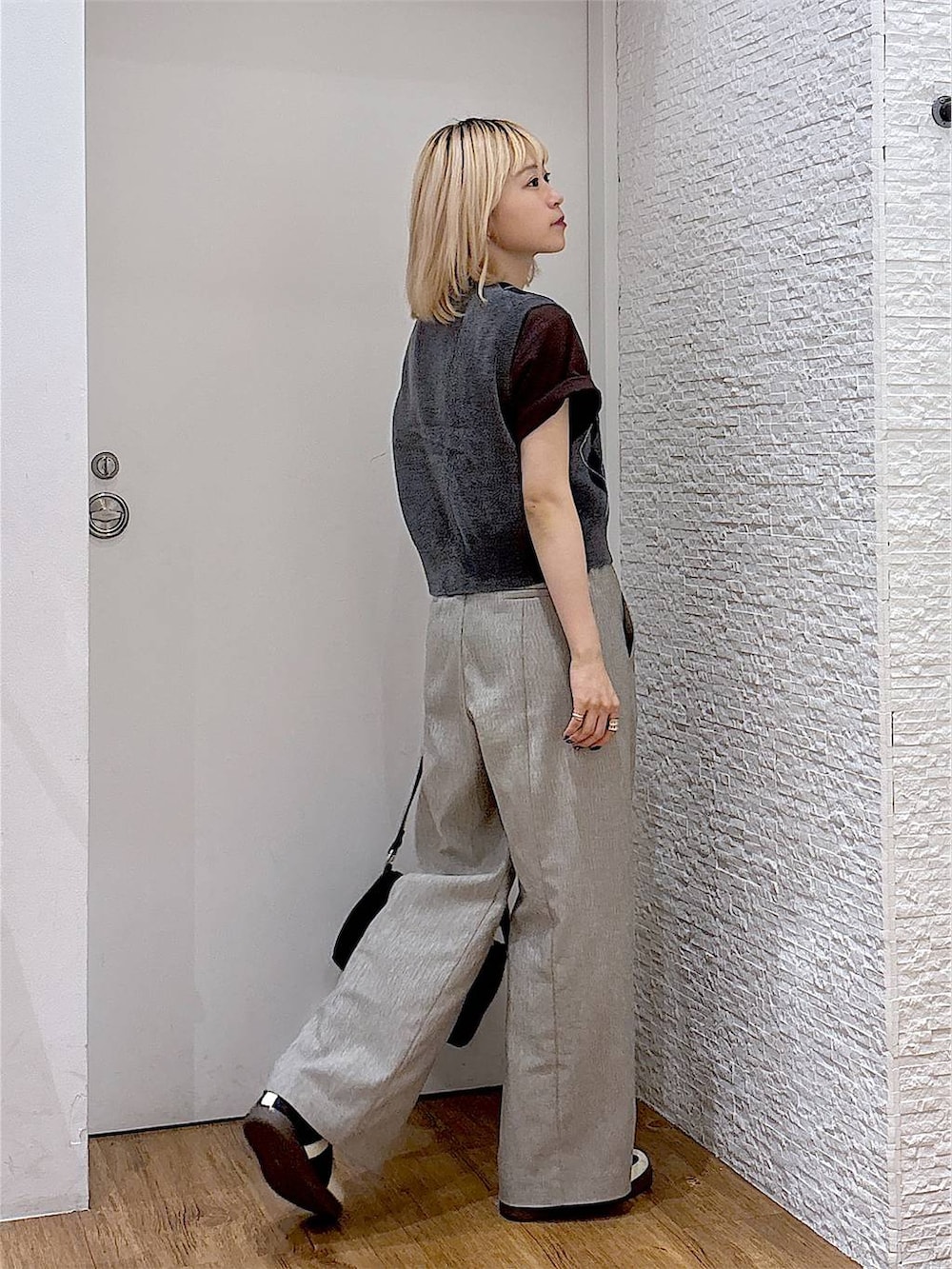 グレー系のベスト、ブラック系のスニーカー、ブラウン系のTシャツ/カットソーを着用したレディースの夏コーディネートの4枚目の写真