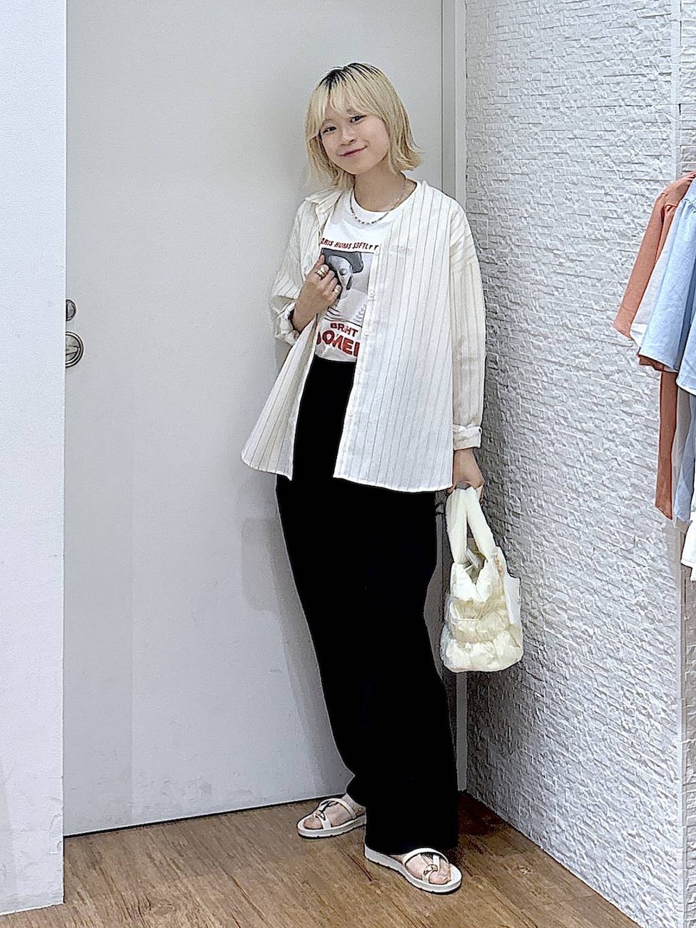ホワイト系のシャツ/ブラウス、ブラック系のトートバッグ、ホワイト系のTシャツ/カットソーを着用したレディースの夏コーディネートの4枚目の写真