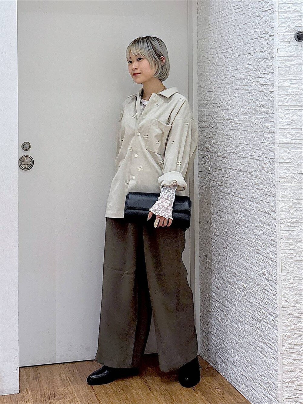 ブラック系のその他シューズ、ブラック系のショルダーバッグ、ホワイト系のTシャツ/カットソーを着用したレディースの秋コーディネートの2枚目の写真