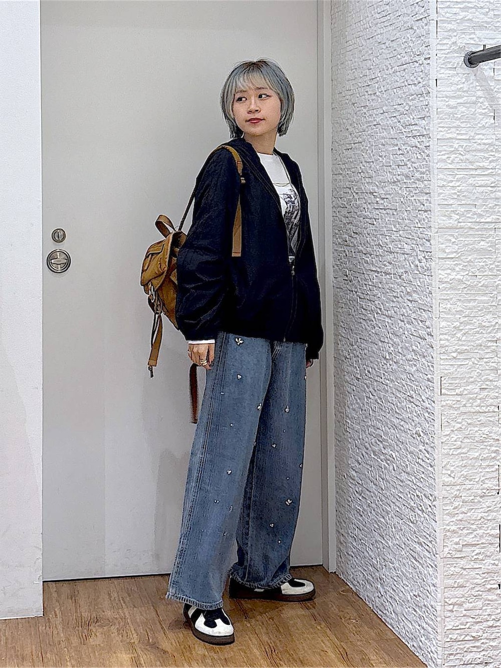 ブラウン系のバックパック/リュック、ホワイト系のTシャツ/カットソー、ブラック系のスニーカーを着用したレディースの秋コーディネートの5枚目の写真