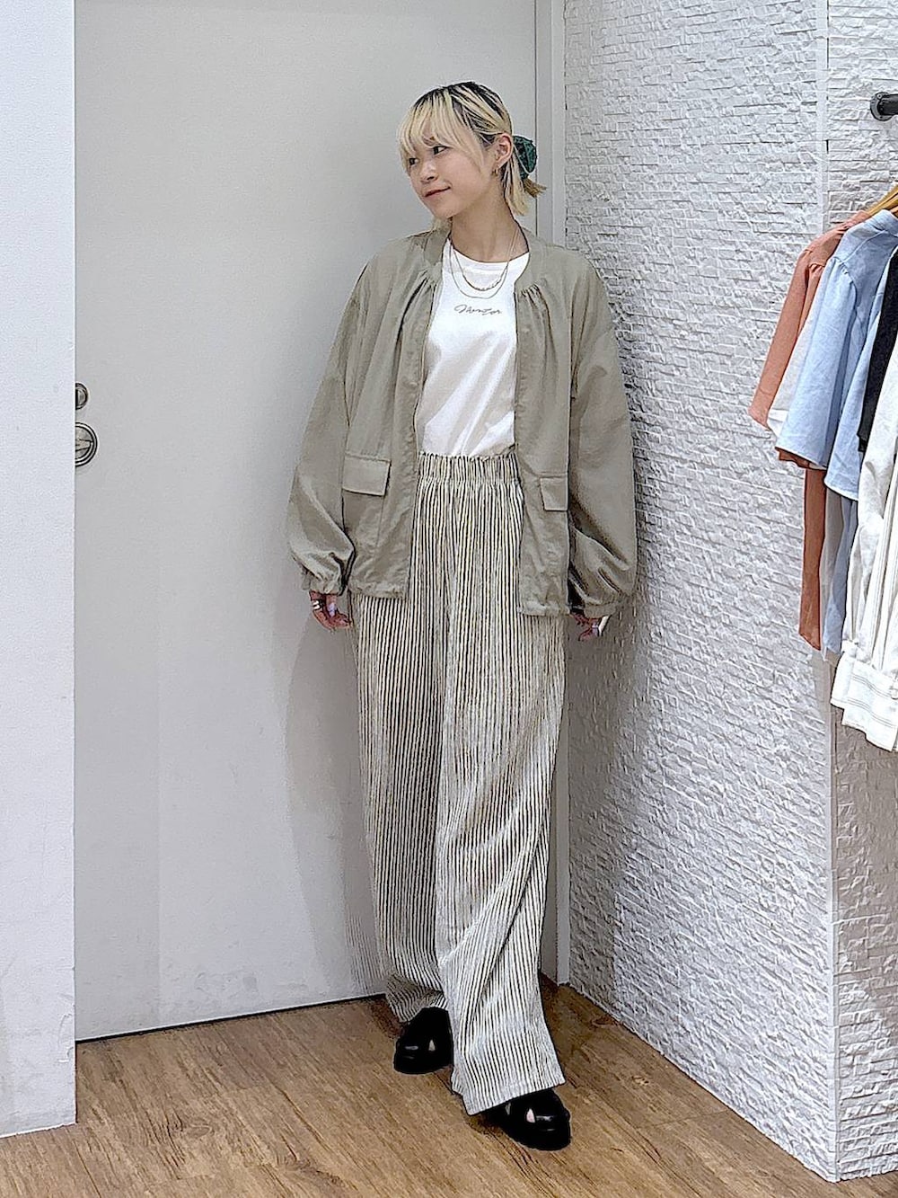 グリーン系のブルゾン、ホワイト系のTシャツ/カットソー、ブラック系のサンダルを着用したレディースの夏コーディネートの5枚目の写真