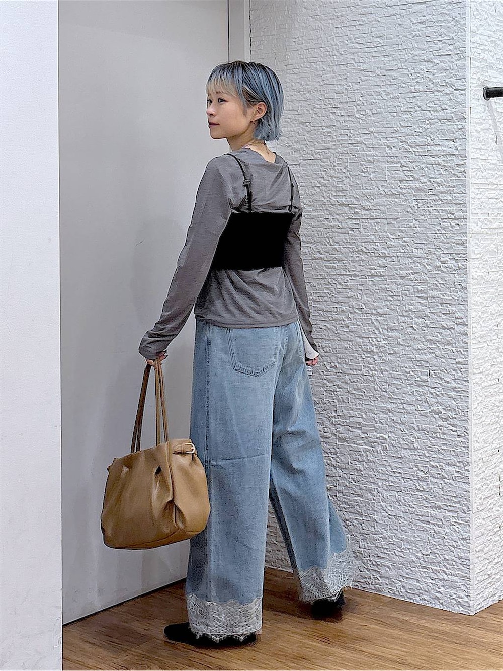 ブラック系のパンプス、グレー系のTシャツ/カットソー、ブルー系のデニムパンツを着用したレディースの秋コーディネートの3枚目の写真