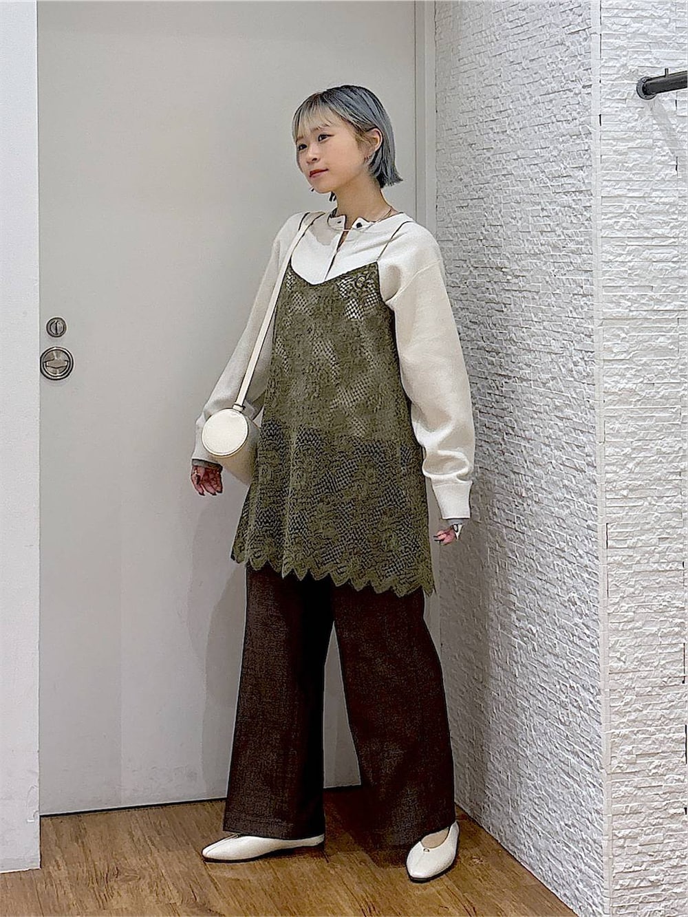 ベージュ系のパンプス、ホワイト系のクラッチバッグ、ブラウン系のその他パンツを着用したレディースの秋コーディネートの2枚目の写真