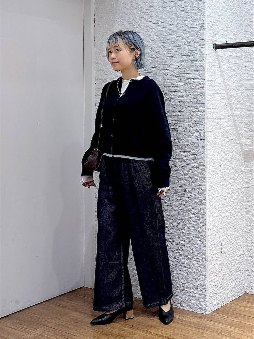 ブラウン系のショルダーバッグ、ホワイト系のTシャツ/カットソー、ブルー系のデニムパンツを着用したレディースの秋コーディネートの2枚目の写真