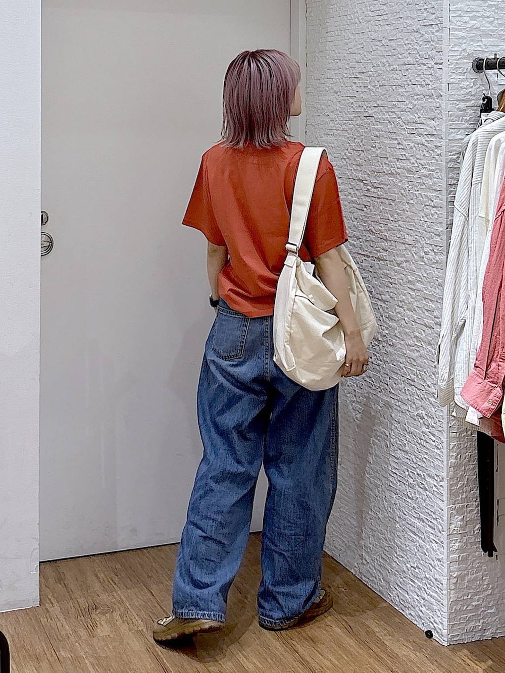ベージュ系のスニーカー、ベージュ系のショルダーバッグ、ブルー系のデニムパンツを着用したレディースの夏コーディネートの4枚目の写真