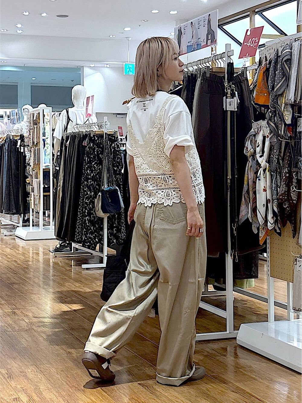 ブラウン系のスニーカー、ブラック系のトートバッグ、ベージュ系のその他パンツを着用したレディースの夏コーディネートの4枚目の写真