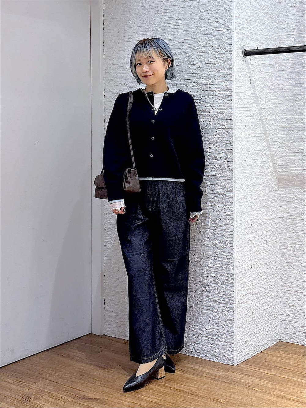ブラウン系のショルダーバッグ、ホワイト系のTシャツ/カットソー、ブルー系のデニムパンツを着用したレディースの秋コーディネートの5枚目の写真
