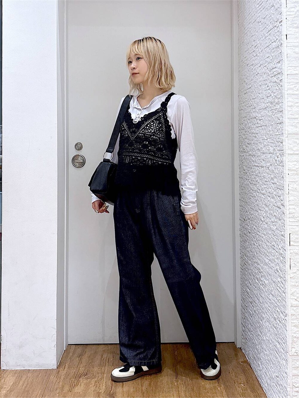 グレー系のTシャツ/カットソー、ブラック系のスニーカー、ブラック系のショルダーバッグを着用したレディースの秋コーディネートの2枚目の写真