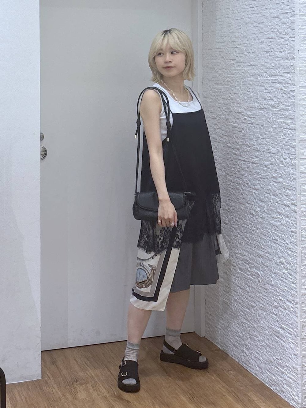 ブラック系のショルダーバッグ、グレー系のタンクトップ、ブラック系のサンダルを着用したレディースの夏コーディネートの5枚目の写真