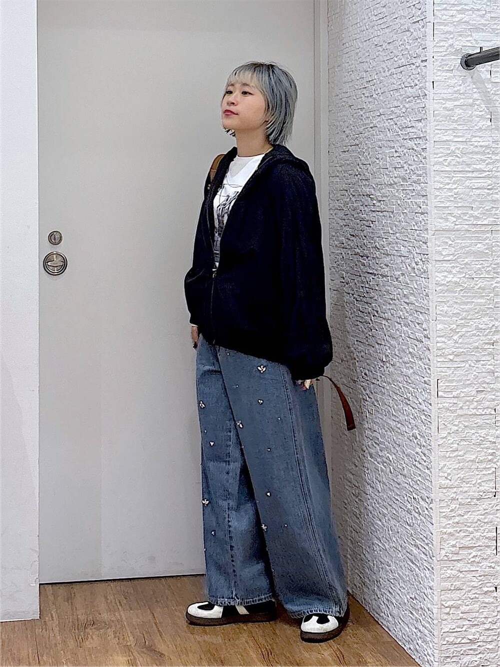 ブラウン系のバックパック/リュック、ホワイト系のTシャツ/カットソー、ブラック系のスニーカーを着用したレディースの秋コーディネートの2枚目の写真