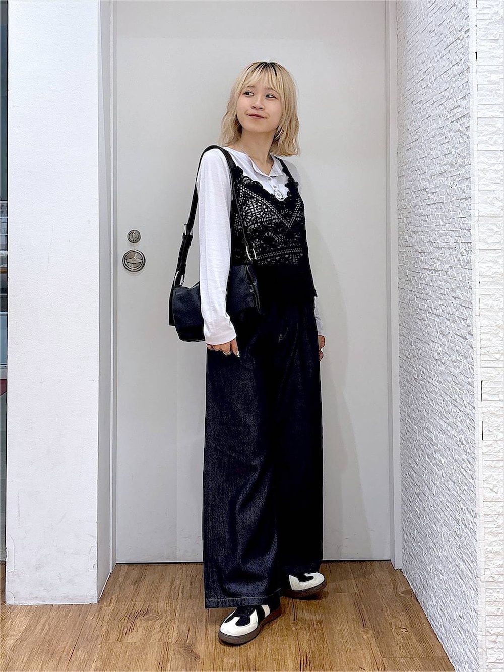 グレー系のTシャツ/カットソー、ブラック系のスニーカー、ブラック系のショルダーバッグを着用したレディースの秋コーディネートの5枚目の写真